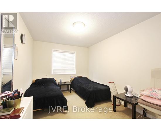 A bedroom with two beds and a table with a fan on it.