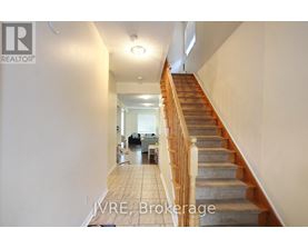 A hallway with a staircase leading to the second floor.