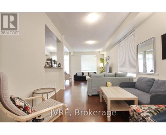 A living room with a grey couch and a white chair.