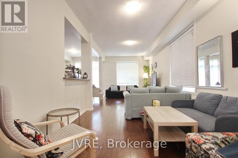 A living room with a grey couch and a white chair.
