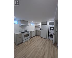 A kitchen with white appliances and wooden floors.