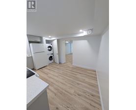 A kitchen with a sink, a refrigerator, and a washing machine.