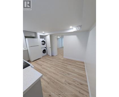 A kitchen with a sink, a refrigerator, and a washing machine.