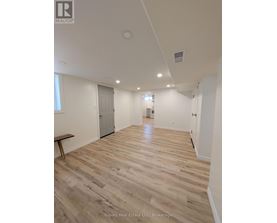 A room with wooden flooring and white walls.