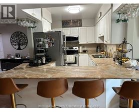 A kitchen with a marble countertop and brown barstools.