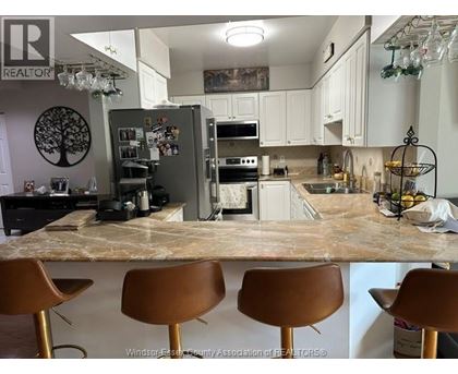 A kitchen with a marble countertop and brown barstools.