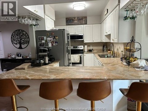 A kitchen with a marble countertop and brown barstools.