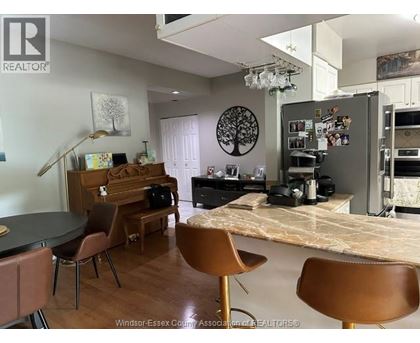 A kitchen with a table and chairs in front of a fridge.