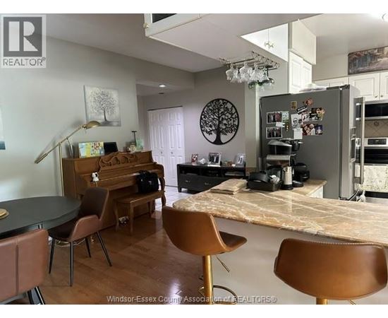 A kitchen with a table and chairs in front of a fridge.