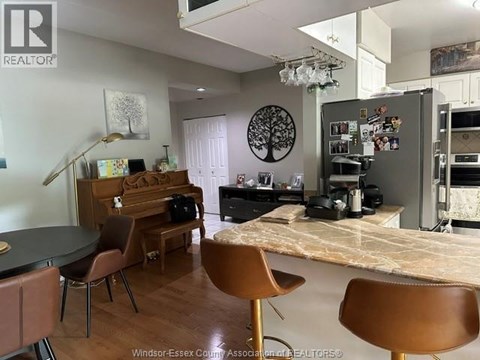 A kitchen with a table and chairs in front of a fridge.