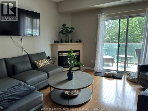 A living room with a grey couch and a fireplace.