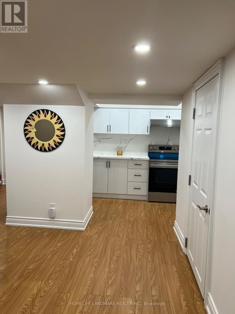 A kitchen with white cabinets and a wooden floor.