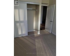 A hallway with carpeted flooring and white doors.
