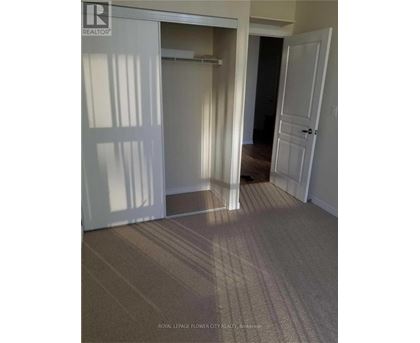 A hallway with carpeted flooring and white doors.