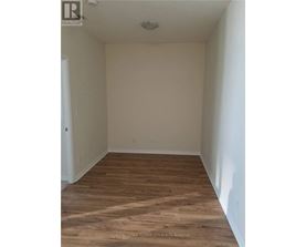 A room with wooden flooring and white walls.