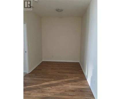 A room with wooden flooring and white walls.