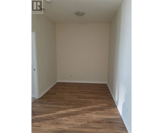 A room with wooden flooring and white walls.