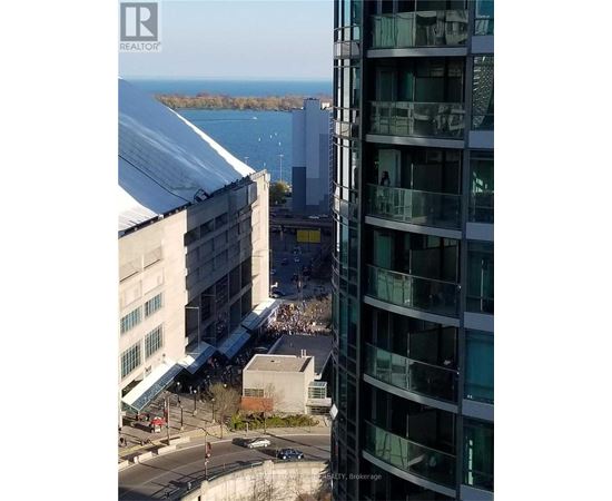 A view from a high-rise building looking down at a busy street with cars and a pedestrian.