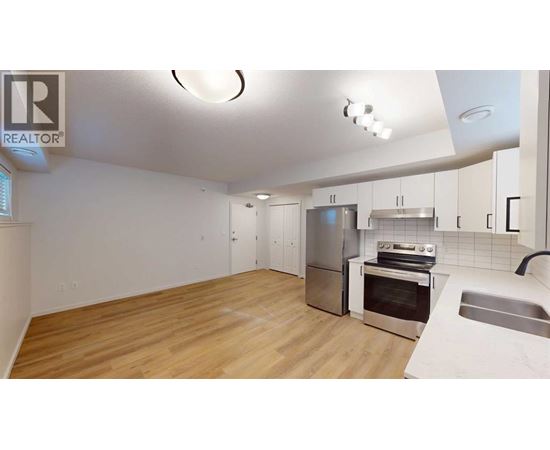 A kitchen with wooden floors and stainless steel appliances.