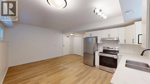 A kitchen with wooden floors and stainless steel appliances.