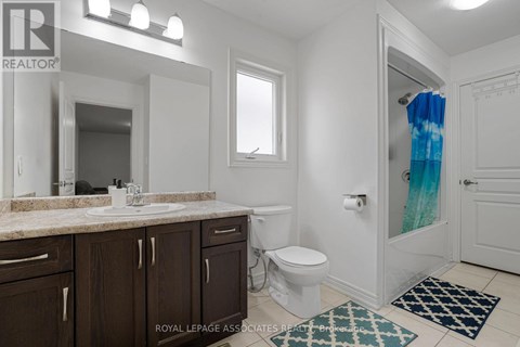 A bathroom with a white toilet, sink, and a blue shower curtain.