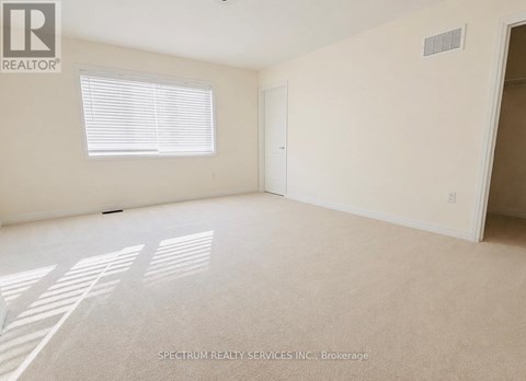 A room with a window and carpeted floor.