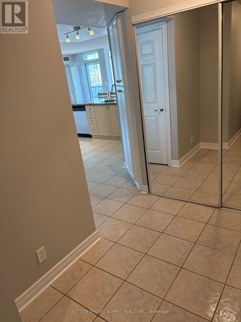 A hallway with a white door and tiled floor.