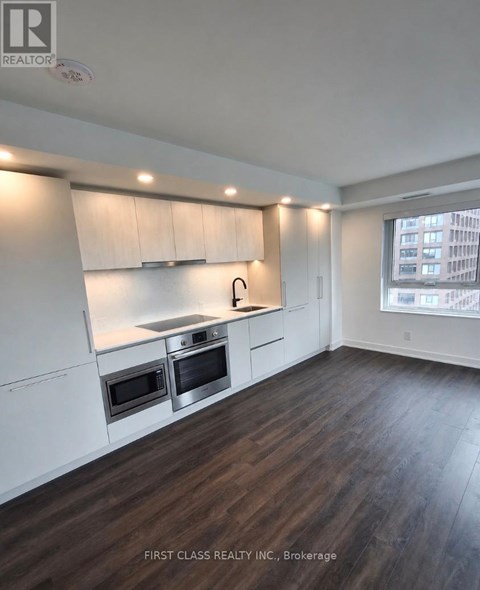 A kitchen with white cabinets and a stainless steel island.