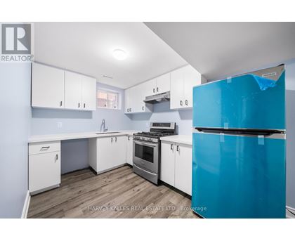A kitchen with white cabinets and a blue fridge.