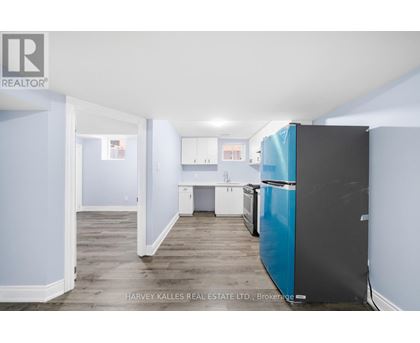 A kitchen with a blue fridge and white cabinets.