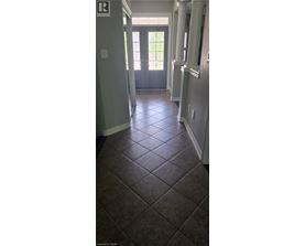 A hallway with a tile floor and a door at the end.
