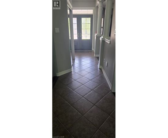 A hallway with a tile floor and a door at the end.