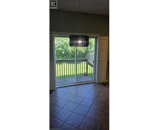 A room with a sliding glass door leading to a backyard.