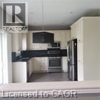 A kitchen with a refrigerator, oven, and microwave.