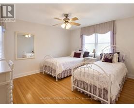 A bedroom with two twin beds and a ceiling fan.