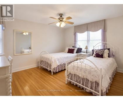 A bedroom with two twin beds and a ceiling fan.
