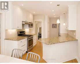 A kitchen with white cabinets and a granite countertop.