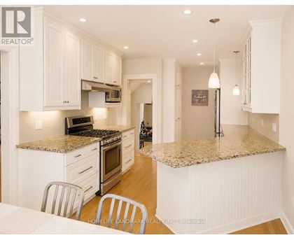 A kitchen with white cabinets and a granite countertop.