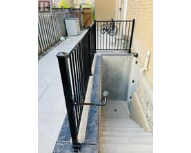 A black metal railing on a concrete staircase.