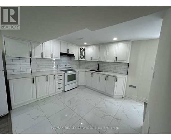 A kitchen with white cabinets and a tiled floor.