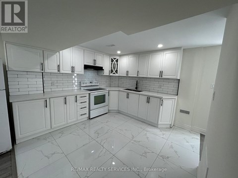 A kitchen with white cabinets and a tiled floor.