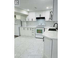 A white kitchen with a tile floor and white cabinets.