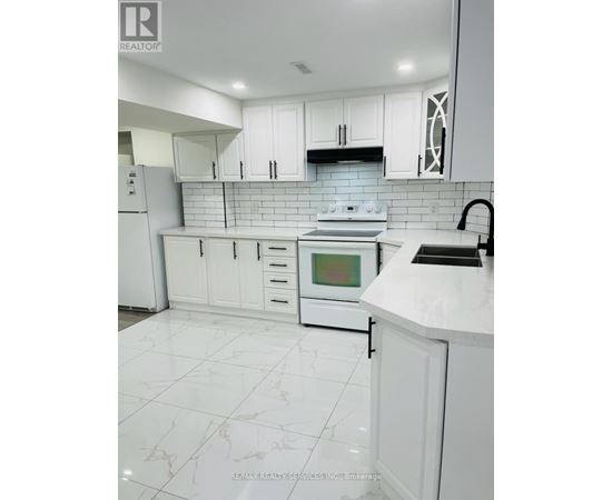 A white kitchen with a tile floor and white cabinets.