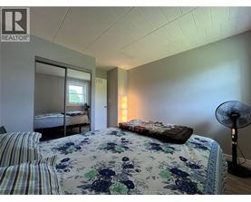 A bedroom with a floral bedspread and striped pillows.