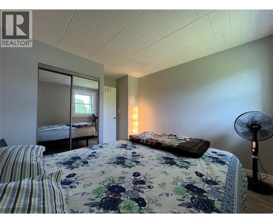 A bedroom with a floral bedspread and striped pillows.