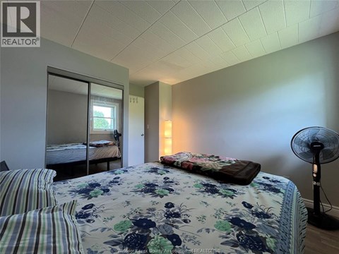 A bedroom with a floral bedspread and striped pillows.