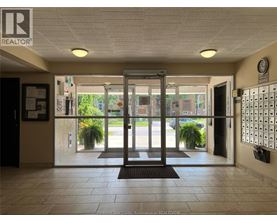The image shows the entrance to a building with a glass door and a sign that reads "REALTOR".
