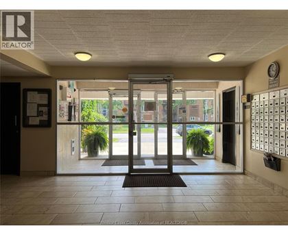 The image shows the entrance to a building with a glass door and a sign that reads "REALTOR".