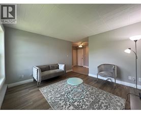 A living room with a grey couch, a chair, and a round table.
