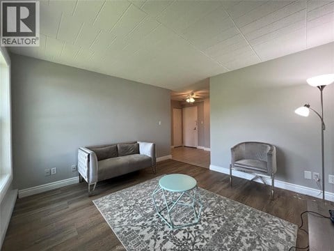 A living room with a grey couch, a chair, and a round table.